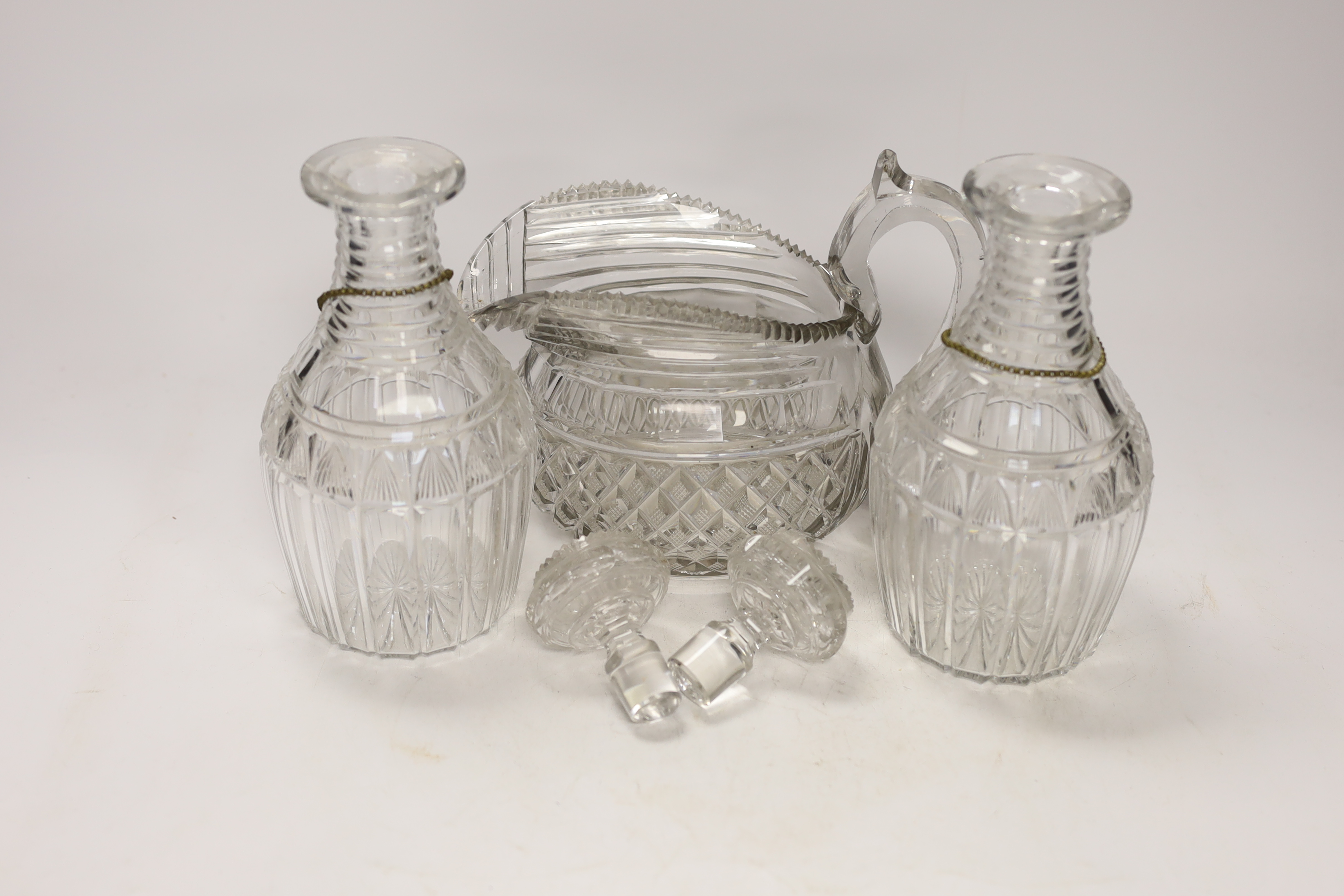 A Regency hobnail and slice cut jug and a pair of Regency cut glass mallet shaped decanters with ‘’Port’’ and ‘’Sherry’’ polychrome enamel labels, 22cm (5)